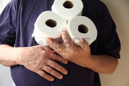 29673165 homme avec la main sur son ventre detient trois rouleaux de papier de toilette